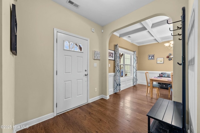 entryway featuring wood finished floors, visible vents, coffered ceiling, arched walkways, and beamed ceiling