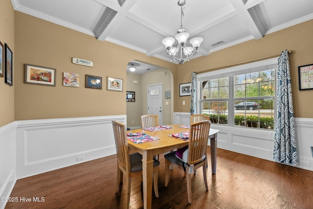 dining space featuring visible vents, a wainscoted wall, coffered ceiling, wood finished floors, and arched walkways