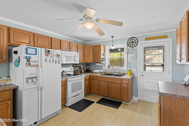 kitchen featuring white appliances, light wood-style floors, brown cabinetry, ceiling fan, and a sink