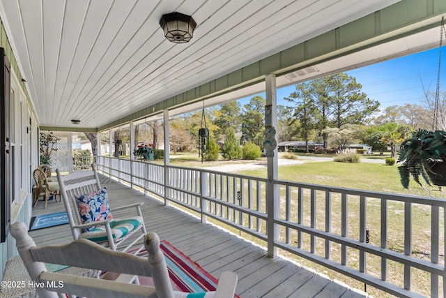 wooden deck featuring a yard and covered porch
