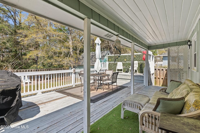 deck with outdoor dining space and fence