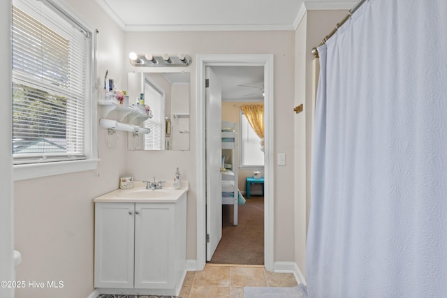 ensuite bathroom with ensuite bathroom, baseboards, ornamental molding, vanity, and tile patterned floors