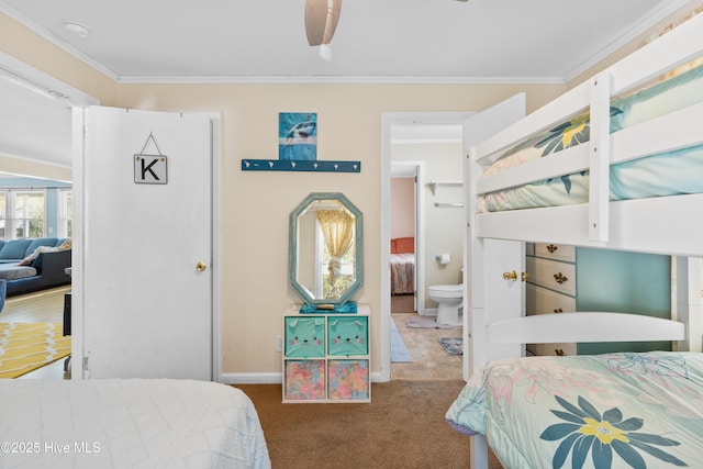 bedroom featuring crown molding, carpet flooring, baseboards, and ensuite bathroom