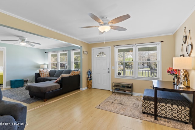 foyer entrance with wood finished floors, ornamental molding, baseboards, and a ceiling fan