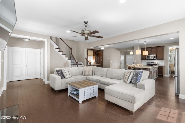 living room with a ceiling fan, dark wood-style flooring, and baseboards