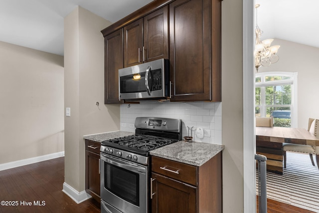 kitchen featuring a notable chandelier, backsplash, dark wood-type flooring, and appliances with stainless steel finishes