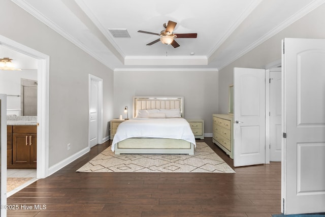 bedroom with a tray ceiling, baseboards, dark wood finished floors, and crown molding