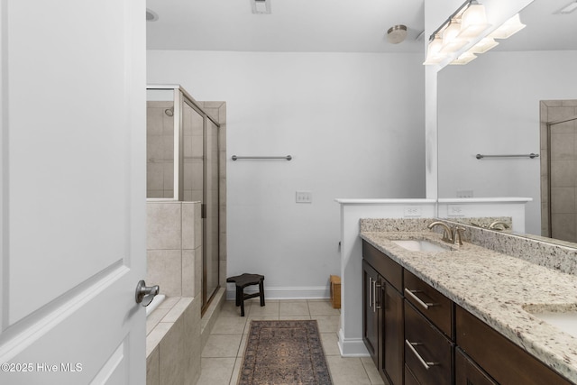 bathroom featuring a sink, double vanity, a shower stall, and tile patterned floors