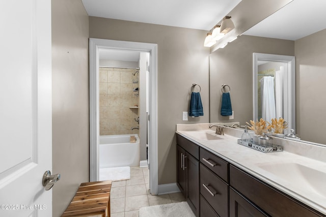 bathroom with a sink, baseboards, double vanity, and tile patterned floors