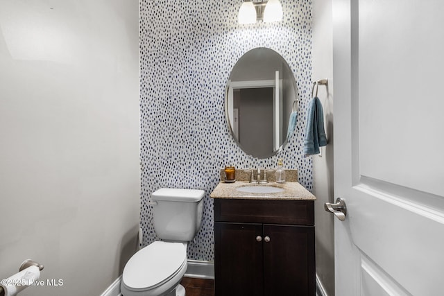 bathroom with backsplash, toilet, vanity, and baseboards