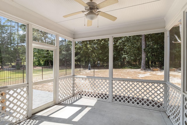 unfurnished sunroom featuring ceiling fan