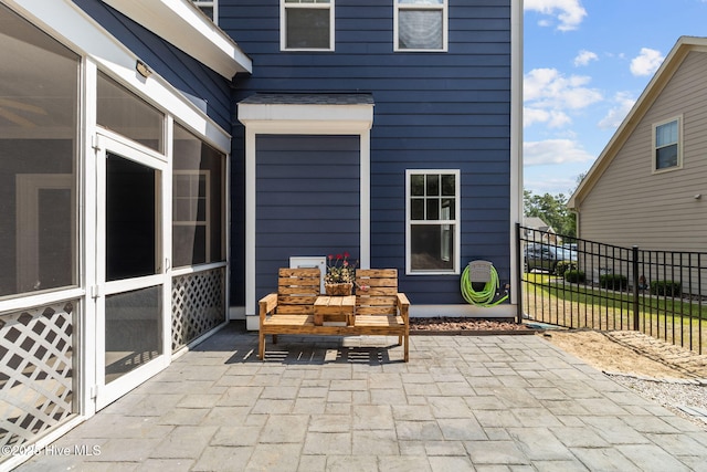 view of patio / terrace with fence and a sunroom