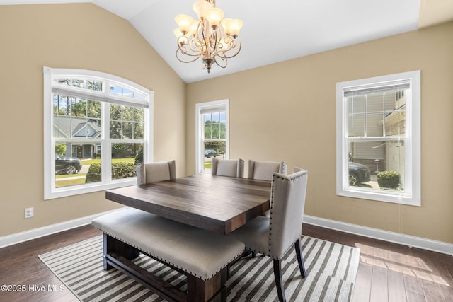 dining space featuring dark wood finished floors, an inviting chandelier, baseboards, and lofted ceiling