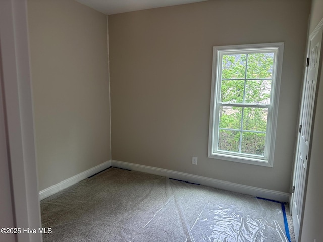 spare room featuring carpet flooring and baseboards