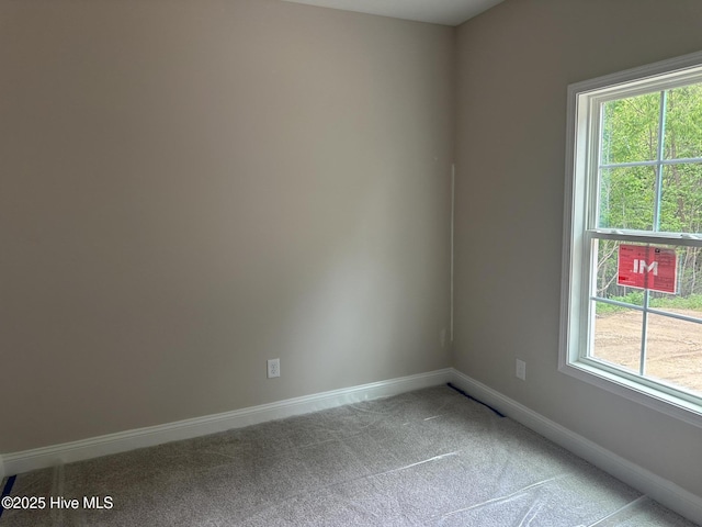 carpeted empty room with baseboards