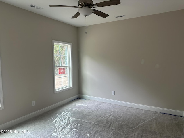 spare room featuring baseboards, carpet floors, a ceiling fan, and visible vents