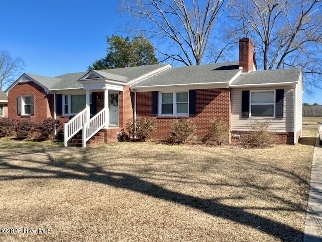 ranch-style house featuring a front lawn, brick siding, roof with shingles, and a chimney