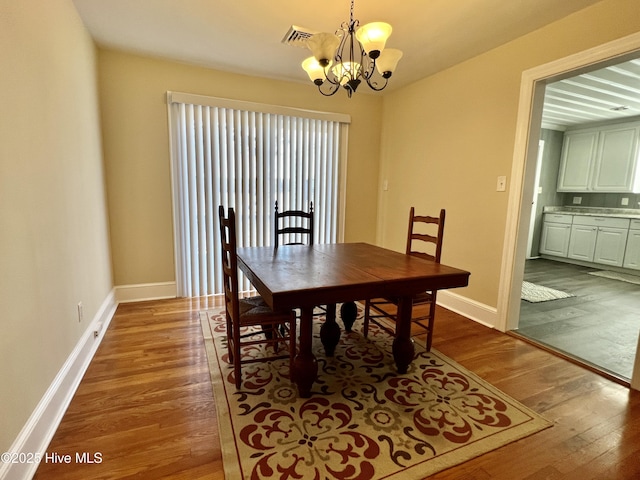 dining area with visible vents, baseboards, an inviting chandelier, and dark wood-style flooring