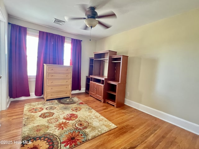 bedroom with ceiling fan, visible vents, baseboards, and light wood-style flooring