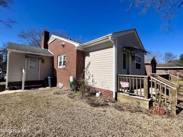 view of home's exterior with a chimney and entry steps