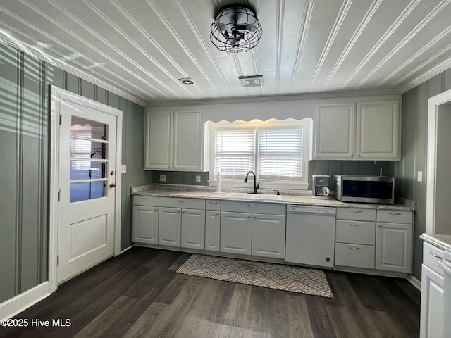 kitchen featuring a sink, stainless steel microwave, dark wood-style flooring, and white dishwasher