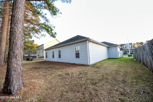 back of house with a lawn and fence