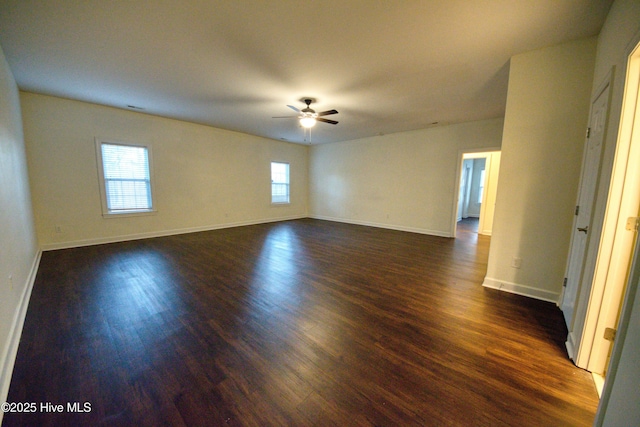 empty room featuring dark wood-style floors, baseboards, and ceiling fan