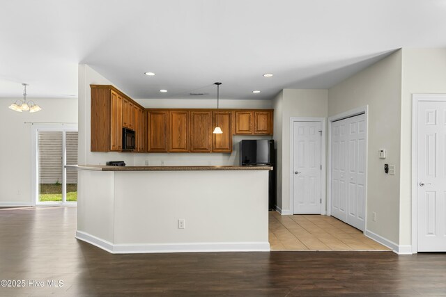 1012 Lake Norman Ln, Leland, NC 28451 - kitchen with light wood finished floors, baseboards, an inviting chandelier, and black appliances