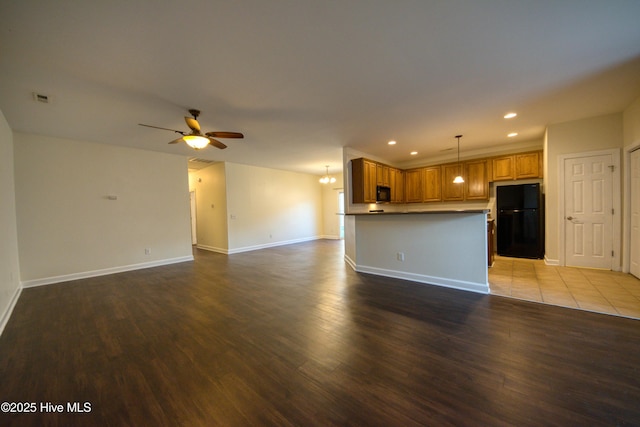 kitchen with wood finished floors, visible vents, ceiling fan, black appliances, and open floor plan