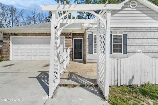 1012 Lake Norman Ln, Leland, NC 28451 - view of front of house featuring roof with shingles, driveway, fence, brick siding, and an attached garage