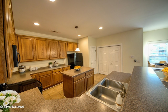 kitchen featuring visible vents, recessed lighting, brown cabinets, black appliances, and a sink