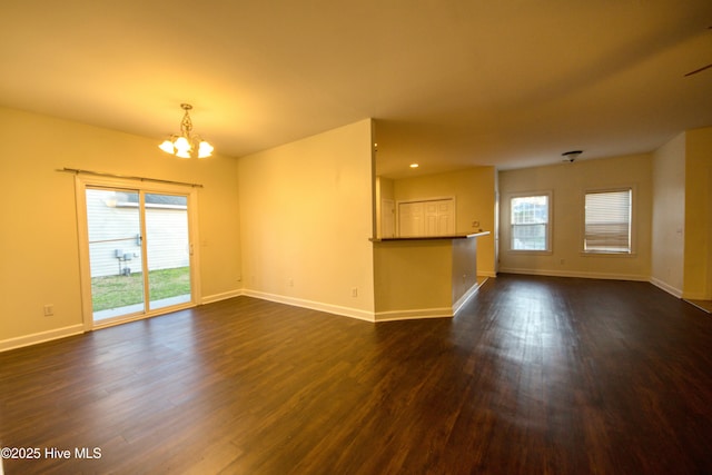 interior space featuring dark wood-style floors, baseboards, and a chandelier