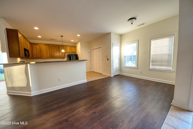 kitchen featuring visible vents, brown cabinets, black appliances, wood finished floors, and recessed lighting