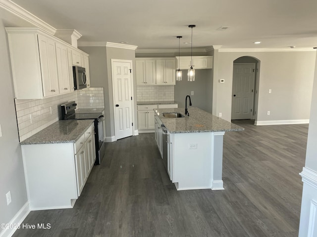 kitchen with stainless steel microwave, white cabinetry, electric stove, and a sink