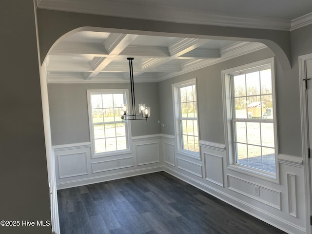 unfurnished dining area featuring an inviting chandelier, dark wood-type flooring, beamed ceiling, and arched walkways