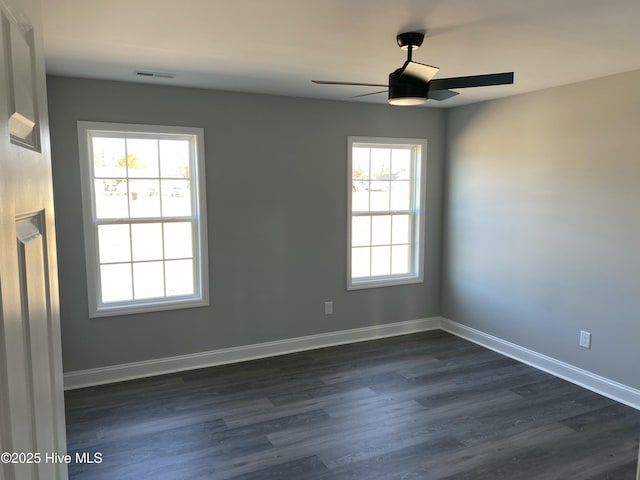 empty room featuring baseboards, dark wood finished floors, and a ceiling fan