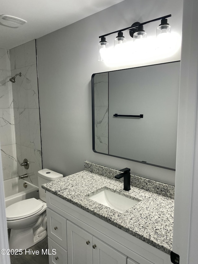 bathroom with visible vents, toilet,  shower combination, and vanity