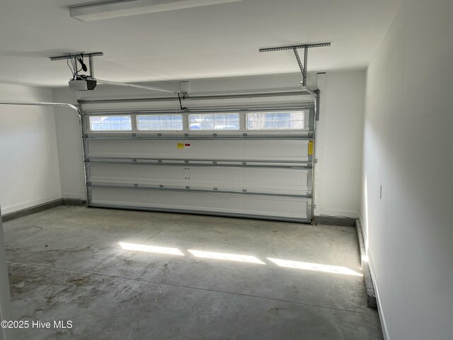 garage featuring a garage door opener and baseboards