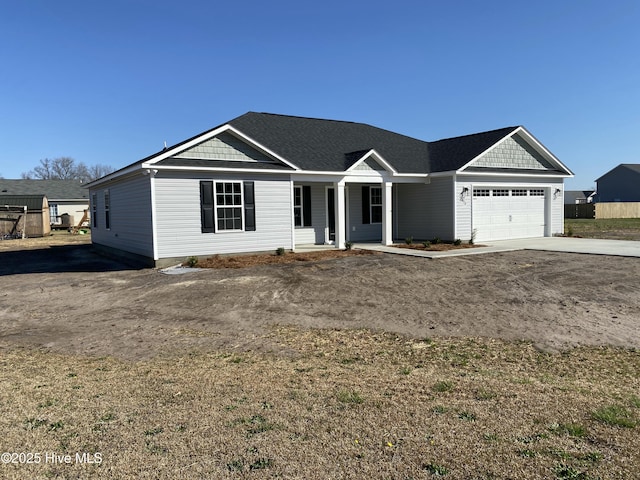 view of front of home with concrete driveway, an attached garage, and a porch