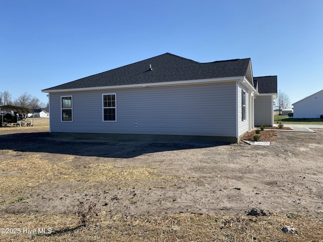 back of property with a shingled roof