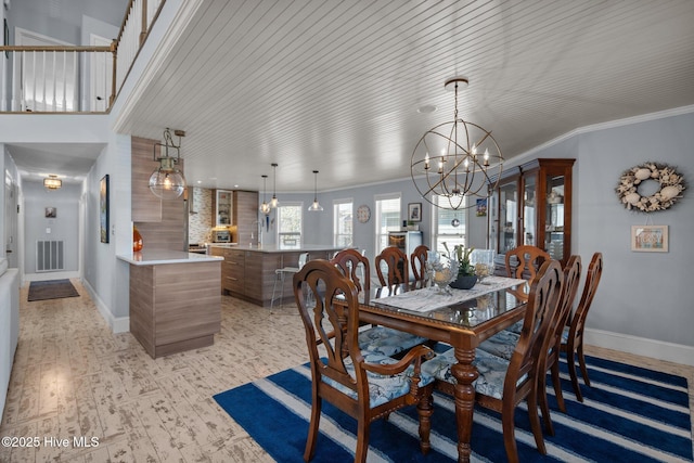 dining space with visible vents, baseboards, an inviting chandelier, and ornamental molding