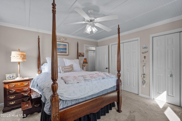 bedroom featuring ceiling fan, baseboards, multiple closets, ornamental molding, and light carpet