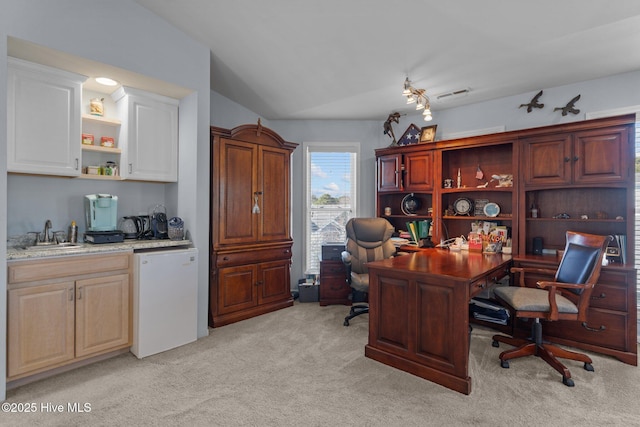 office featuring vaulted ceiling, visible vents, light colored carpet, and a sink