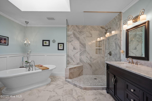 bathroom featuring a freestanding tub, a wainscoted wall, marble finish floor, ornamental molding, and a walk in shower