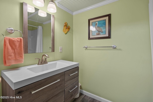 full bath with vanity, wood finished floors, baseboards, ornamental molding, and curtained shower