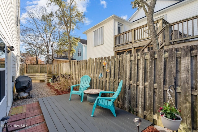 deck with a fenced backyard and grilling area