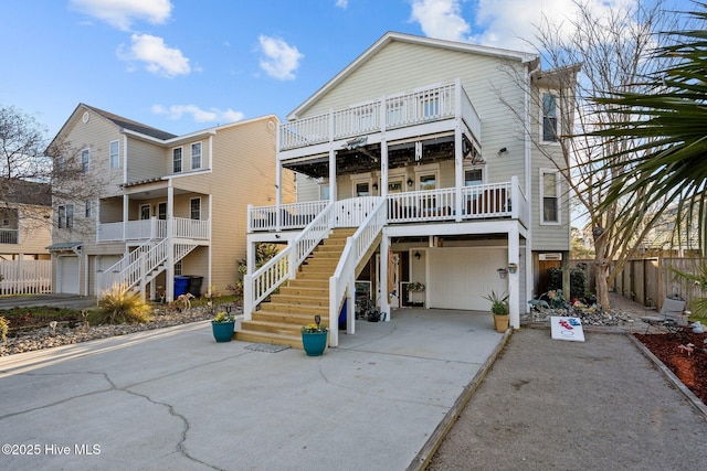 raised beach house with stairway, a garage, and driveway