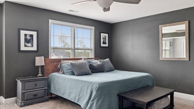 carpeted bedroom with baseboards, visible vents, and ceiling fan