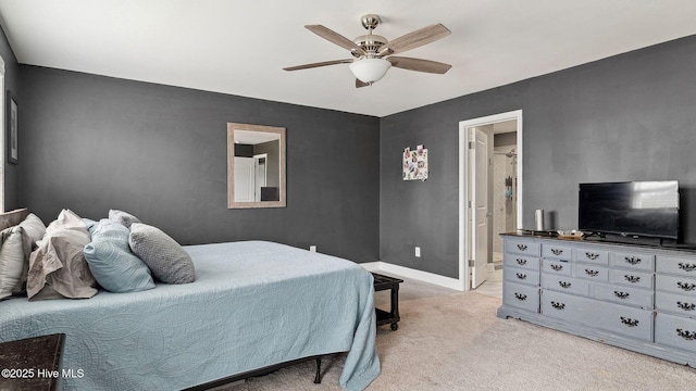 bedroom featuring ceiling fan, connected bathroom, baseboards, and light carpet