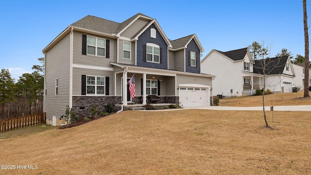 craftsman-style home featuring stone siding, covered porch, concrete driveway, a front yard, and a garage